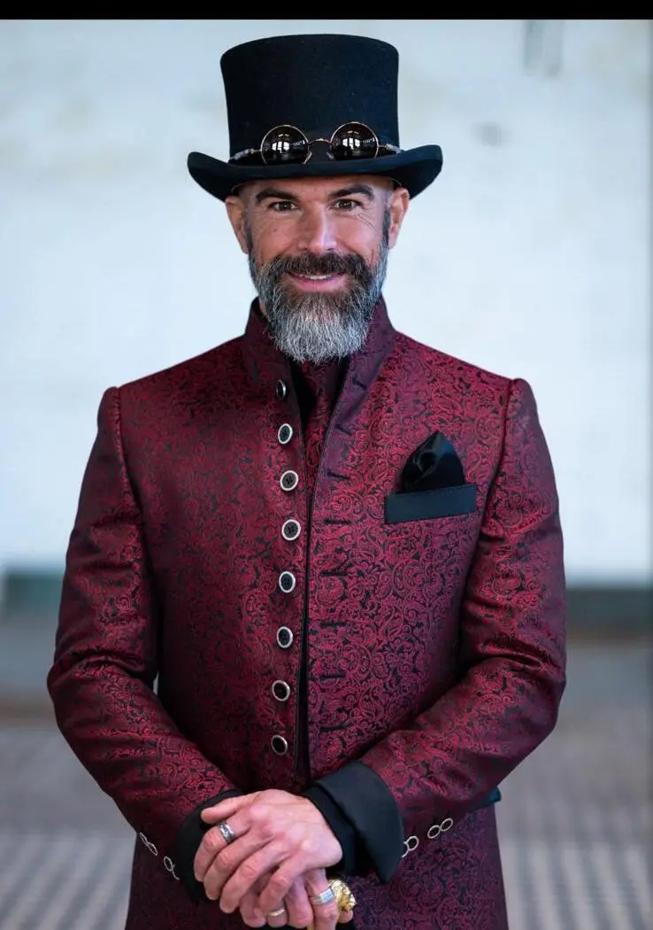 Porträt: Couture Stehkragen-Sakko mit Zylinder, burgunderrot mit Paisley-Muster